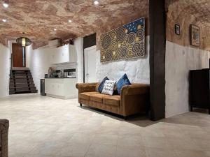 a living room with a couch and a kitchen at Cozy Cave Coober Pedy in Coober Pedy
