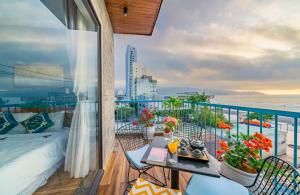 balkon z łóżkiem i stołem na balkonie w obiekcie Cani Beach House w mieście Da Nang