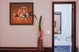 a bathroom with a picture on the wall and a vase at HueNam Residence in Hue