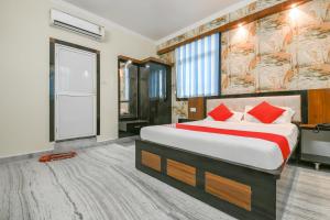 a bedroom with a large bed with red pillows at Flagship 79796 Hotel Royal Inn in Gulzārbāgh