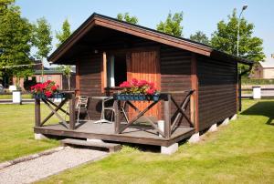 a small cabin with a table and chairs in a yard at Hotell Milano in Åstorp