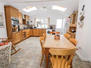 a kitchen with a wooden table and chairs at Ty Gwynn in Tanygrisiau