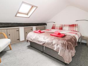 a bedroom with a bed with two pink towels on it at Ty Gwynn in Tanygrisiau