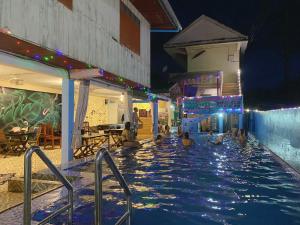un grupo de personas en una piscina por la noche en Vang Vieng Freedom Backpackers en Vang Vieng