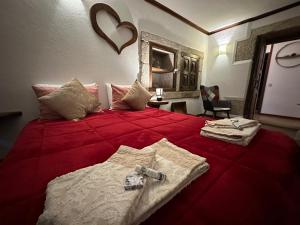 a bedroom with a red bed with towels on it at Casa da Cerca in Sortelha