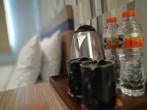 a coffee pot and two bottles of water on a table at All Nite and Day Hotel Alam Sutera in Serpong