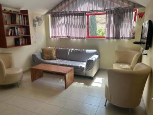 a living room with a couch and a table at Gilboa Guest House - Benharim in Gid‘ona