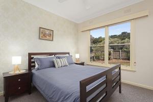 a bedroom with a large bed and a window at Curragundi in Point Lonsdale