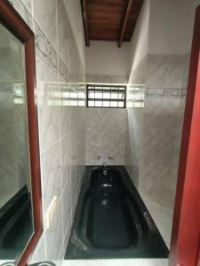 a bath room with a tub in a tiled bathroom at Casa Campestre Poblado para 8 in Medellín
