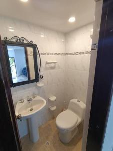 uma casa de banho com um WC branco e um lavatório. em Casa Campestre Poblado para 8 em Medellín