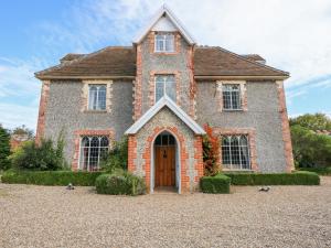 a brick house with birds standing in front of it at Southrepps Lodge in Norwich