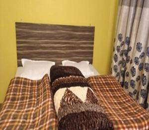 uma cama com cobertores e almofadas num quarto em The Moksha Hasling by StayApart em Pithorāgarh