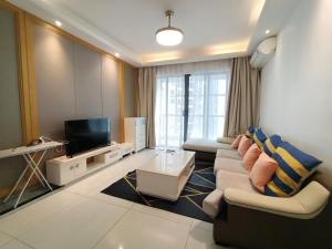uma sala de estar com um sofá e uma televisão em R&F Princess cove Sweety Homestay 3beds2baths em Johor Bahru
