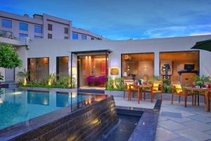 a house with a pool and a table and chairs at Royale Sarovar Portico Agra in Agra