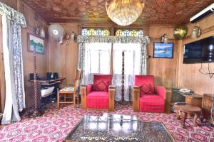 a living room with two red chairs and a table at HB Zaindari Palace in Srinagar