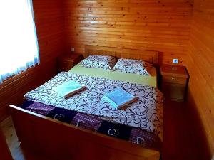 ein Schlafzimmer mit einem Bett mit einer Holzwand in der Unterkunft ECO ViLLAGE CORIC in Mojkovac