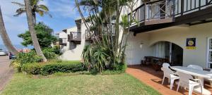 a patio with a table and chairs next to a building at 4 La Toinette in Ballito