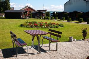 a picnic table and two chairs in a park at Hotell Milano in Åstorp