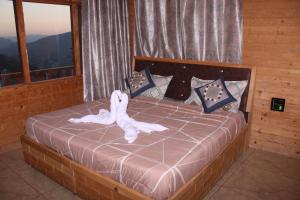 een slaapkamer met een bed met een witte handdoek erop bij Hotel Mannat Sach Pass in Tisa