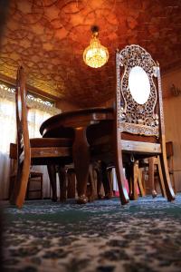 een eettafel met 2 stoelen en een kroonluchter bij HB Zaindari Palace in Srinagar