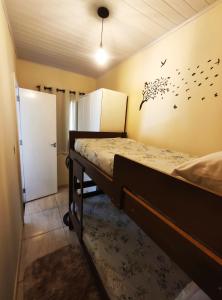 a bedroom with a bed with birds on the wall at Kitnet Sol - Mobiliada in Belo Horizonte