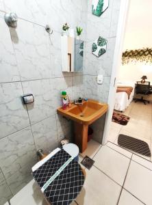 a bathroom with a sink and a mirror and a toilet at Kitnet Sol - Mobiliada in Belo Horizonte