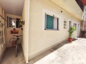 a bike parked next to a wall with a window at Kitnet Sol - Mobiliada in Belo Horizonte