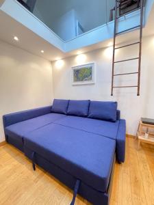 a large blue bed in a room with a ladder at Lovely studio at Île Saint-Louis in Paris