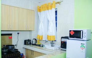 eine Küche mit einem weißen Kühlschrank und einer Mikrowelle in der Unterkunft Epic Village in Nairobi