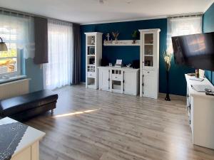 a living room with blue walls and a wooden floor at Reethaus Zickersche Berge - WG 02 mit Kamin und Terrasse in Gager