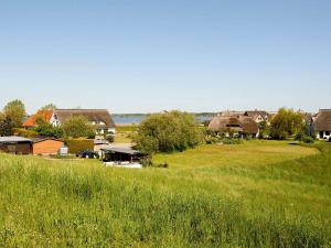 a village with a field of grass and houses at Reethaus Zickersche Berge - WG 02 mit Kamin und Terrasse in Gager