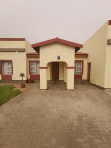 a house with a driveway in front of it at Oasis Self-Catering in Swakopmund