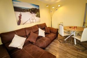 sala de estar con sofá marrón y mesa en MODERNO APARTAMENTO MUY CERCA DE BARCELONA, en Mollet del Vallès
