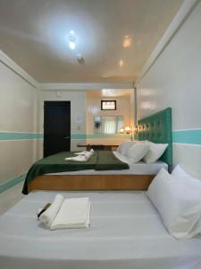 a bedroom with a large bed with a mirror at Casa Marie Hotel in Daet