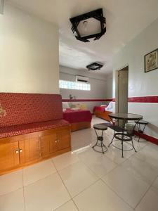 a living room with a red couch and a table at Casa Marie Hotel in Daet