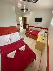 - une chambre avec un grand lit et une couverture rouge dans l'établissement Casa Marie Hotel, à Daet