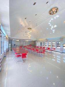 a cafeteria with red tables and red chairs at Casa Marie Hotel in Daet
