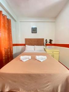 a bedroom with a large bed with two pillows at Casa Marie Hotel in Daet +15 photos