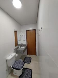 uma casa de banho com um WC, um lavatório e um espelho. em Bela casa nova na Chapada dos Guimarães em Chapada dos Guimarães