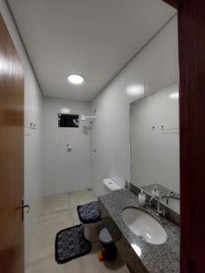 uma casa de banho com um lavatório e um espelho grande em Bela casa nova na Chapada dos Guimarães em Chapada dos Guimarães
