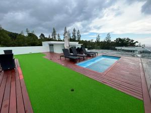 a backyard with a pool and green grass at Twin Sands Resort Penthouse in Patong Beach