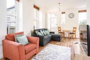 a living room with a couch and a table at Spacious 2 Bedroom House With Stunning Views in Bath