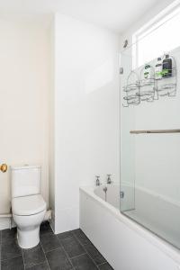 uma casa de banho branca com um WC e um chuveiro em Stunning 3 Bedroom Period City Centre Apartment em Bath