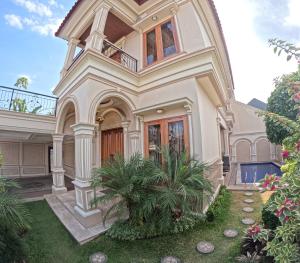 a large white house with a balcony at Villa Casa Baiti Syariah Malioboro in Jetis