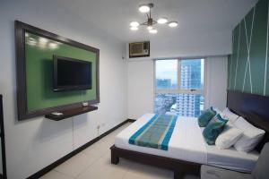 um quarto com uma cama e uma televisão de ecrã plano em Millenia Suites Cozy Studio Unit 3003 em Manila