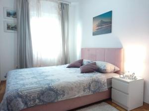 um quarto com uma cama com almofadas e uma janela em EMA LUX - zgrada Panorama em Sokobanja