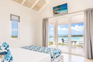 a bedroom with a bed and a view of the ocean at NEW Tropical Waterfront Cooper Jack Bay Villas in Five Cays Settlement