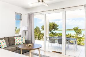 ein Wohnzimmer mit einem Sofa und einem Tisch in der Unterkunft NEW Tropical Waterfront Cooper Jack Bay Villas in Five Cays Settlement