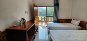a hotel room with two beds and a desk and a window at Nongkhaiw river view in Nongkhiaw