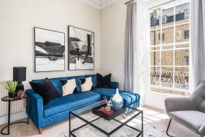 a living room with a blue couch and a window at BRAND NEW LISTING Beautiful 2 bedroom apartment in Bath